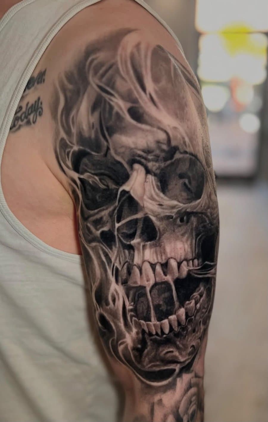 Realistisches Totenkopf-Tattoo mit Rauch auf dem Oberarm von Andrei Tiron Schleswig-Holstein